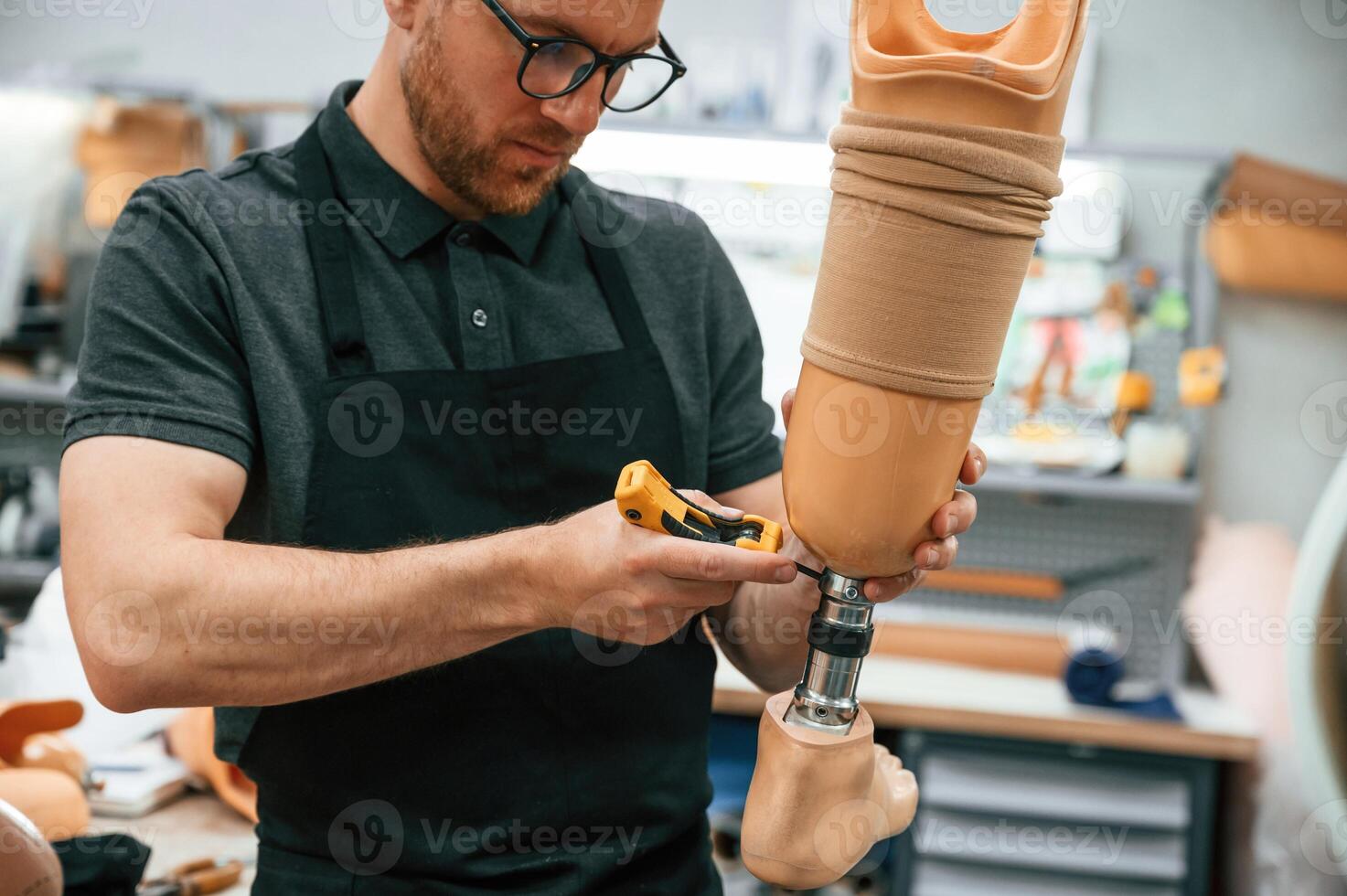 Tightening, the, screws. Technician working with prosthesis in modern laboratory photo