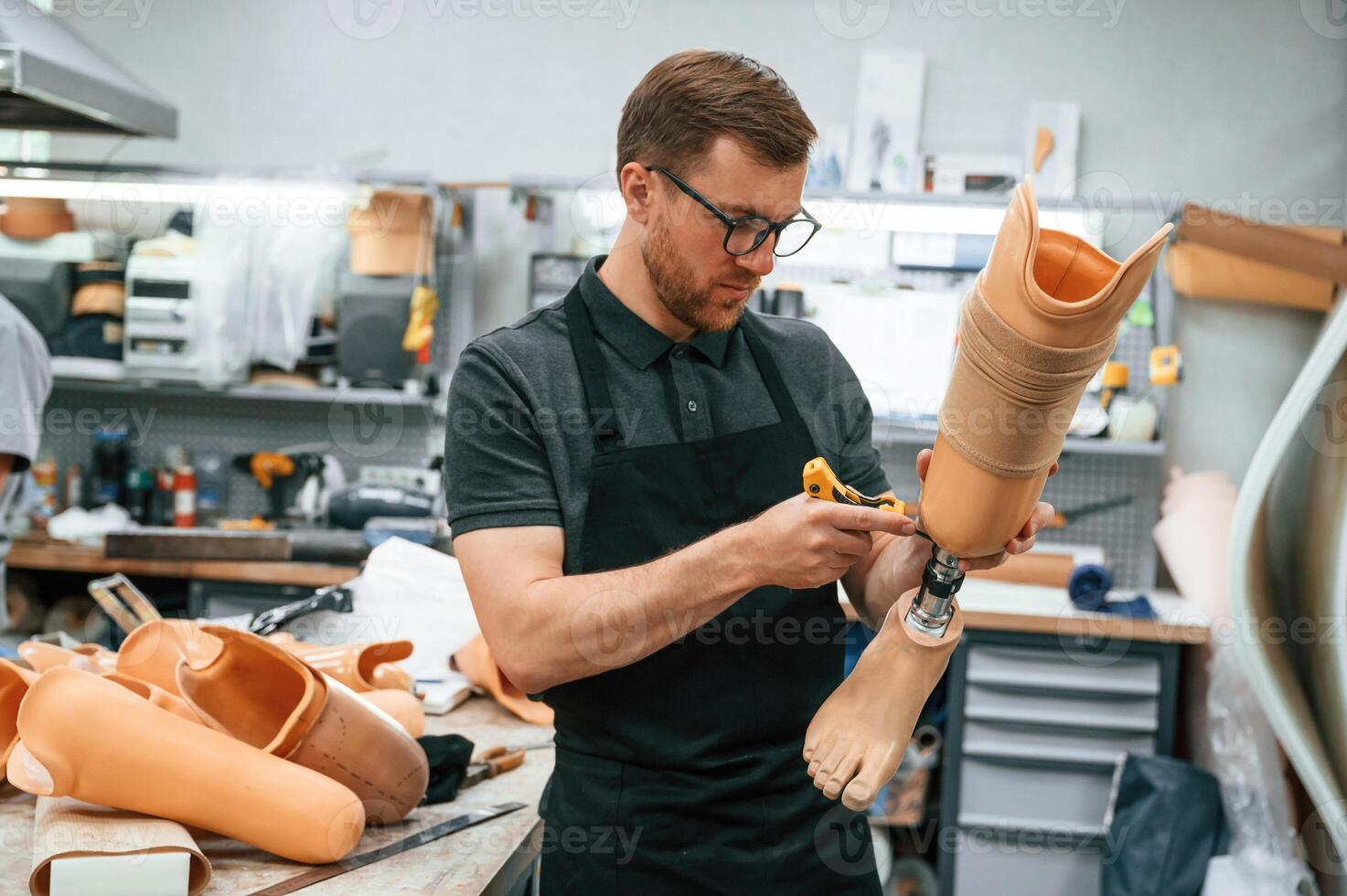 Tightening, the screws. Technician working with prosthesis in modern laboratory photo