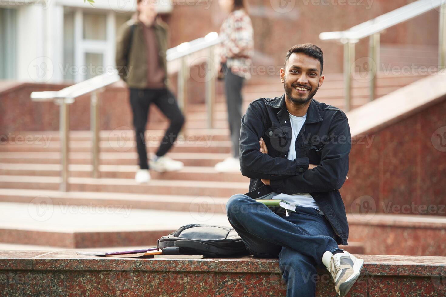 Positive Indian man,. Young students in casual clothes are together outdoors photo