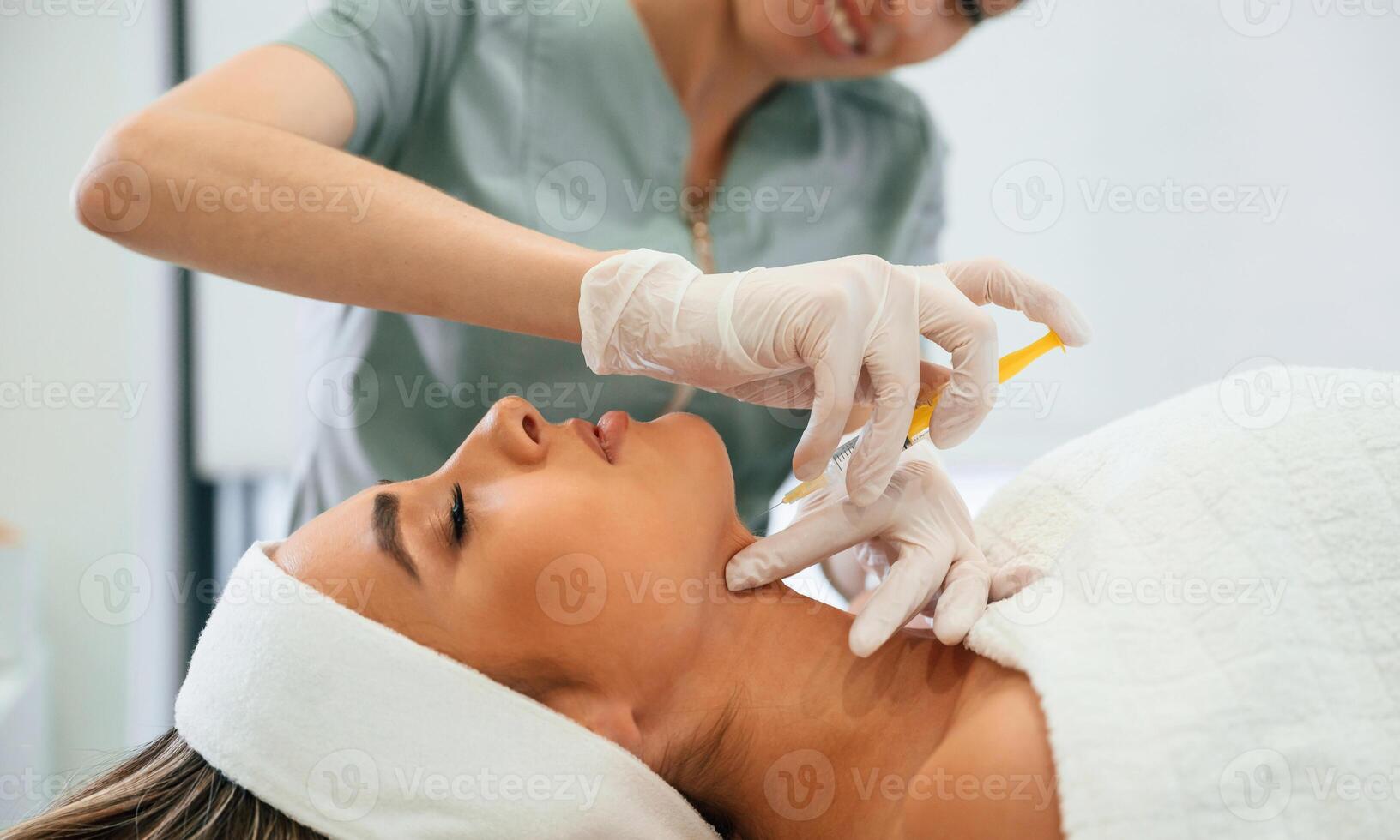 Yellow, colored ,syringe, making, injection. Woman face getting facial care by beautician hands at spa salon photo