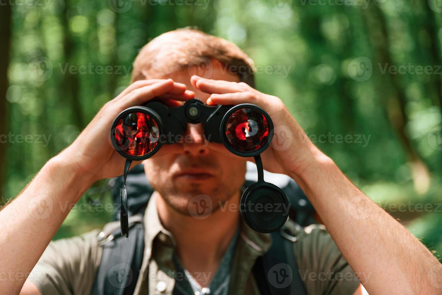 Looking through the binoculars. .Tourist, in summer forest. Conception of exploration and leisure photo