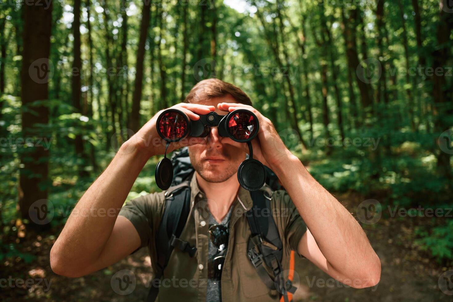 Looking, through ,the binoculars. Tourist in summer forest. Conception of exploration and leisure photo