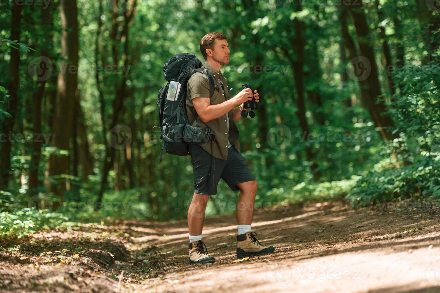 Beautiful sunlight through ,the, trees. Tourist in summer forest. Conception of exploration and leisure photo