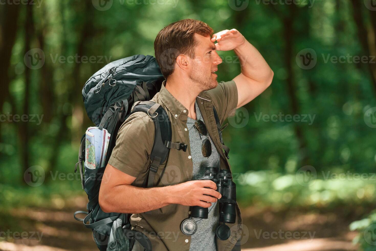 Navigation ,conception. With binoculars. Tourist in summer forest photo