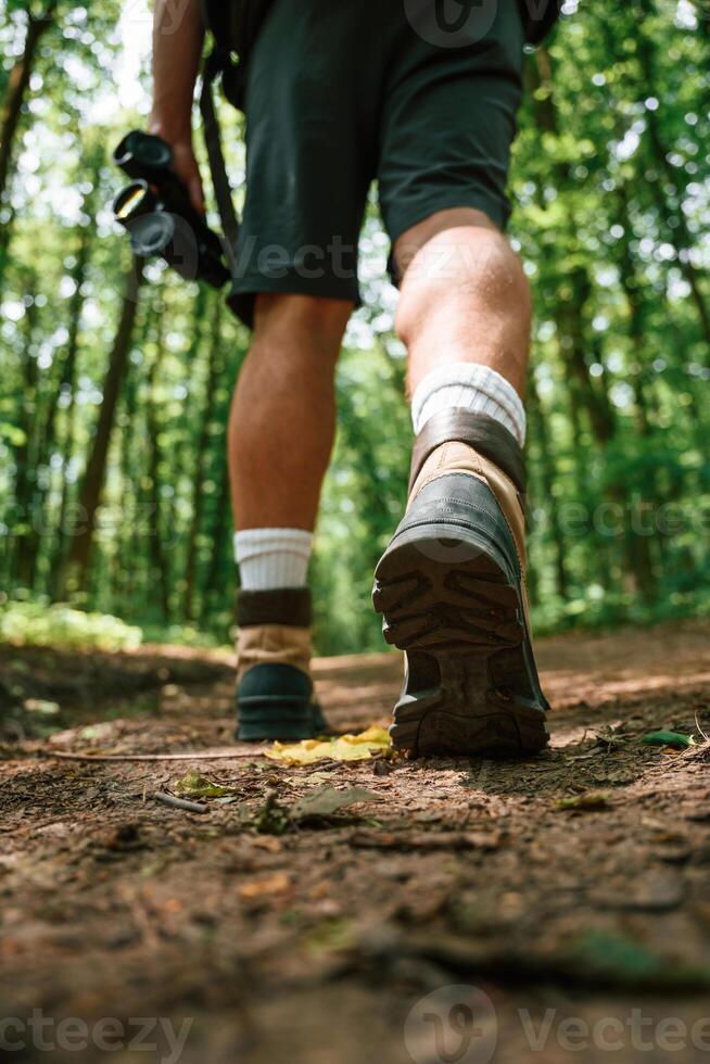 Close up rear view of tourist legs that is in summer forest photo