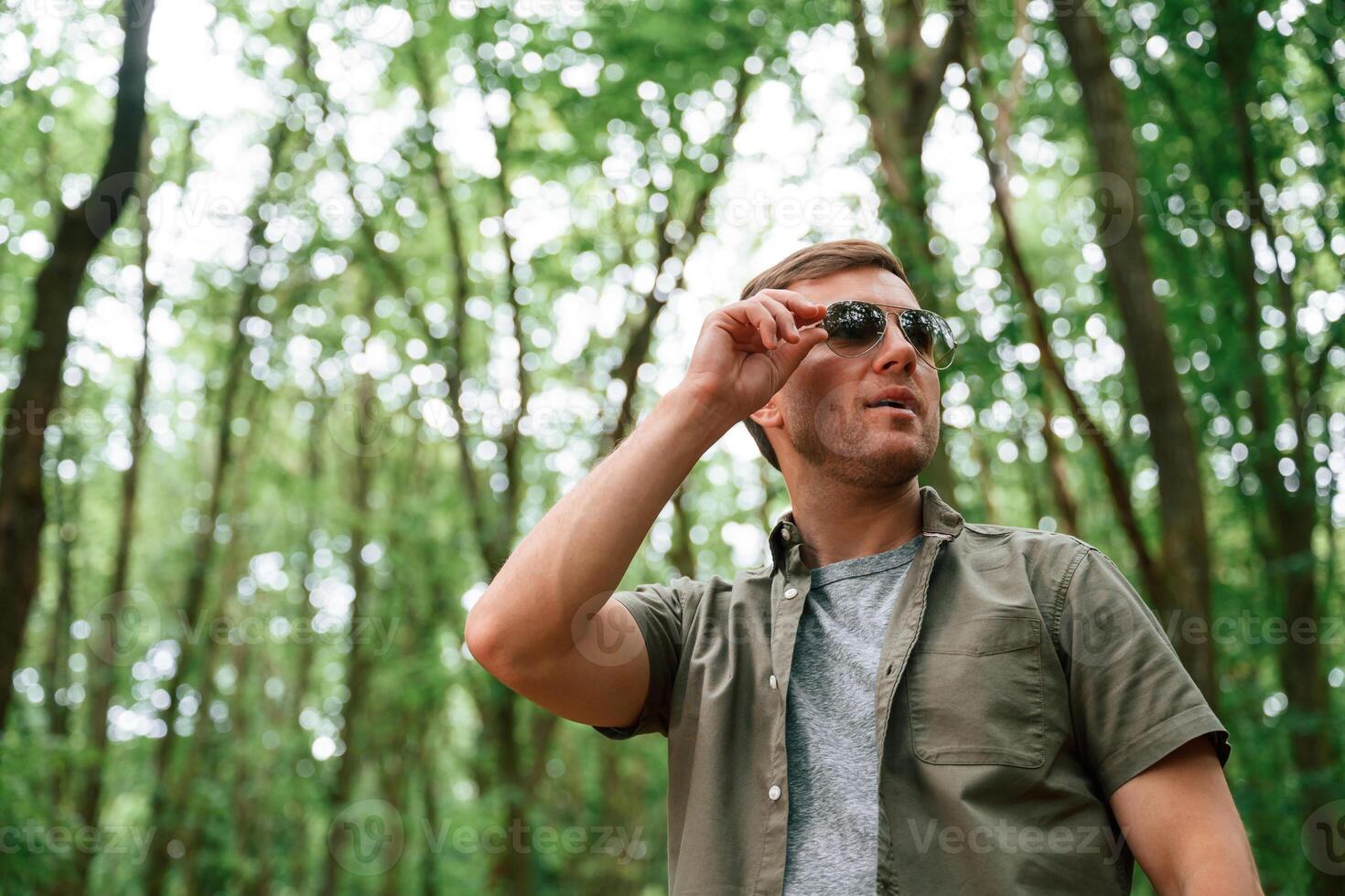 In sunglasses. Tourist, in summer forest. Conception of exploration and leisure photo