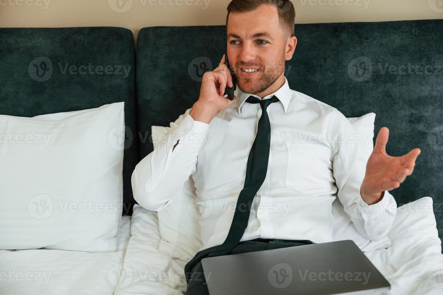 Phone,, conversation.. Businessman is indoors in the hotel room photo