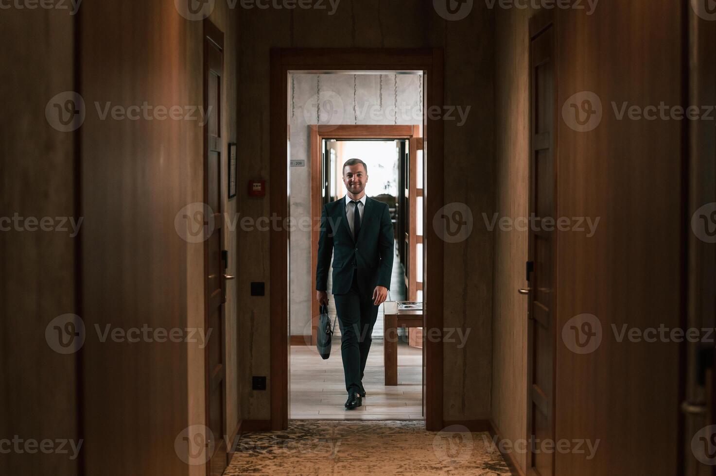 Front ,view, in the, appartment. Handsome businessman is indoors in the hotel room photo