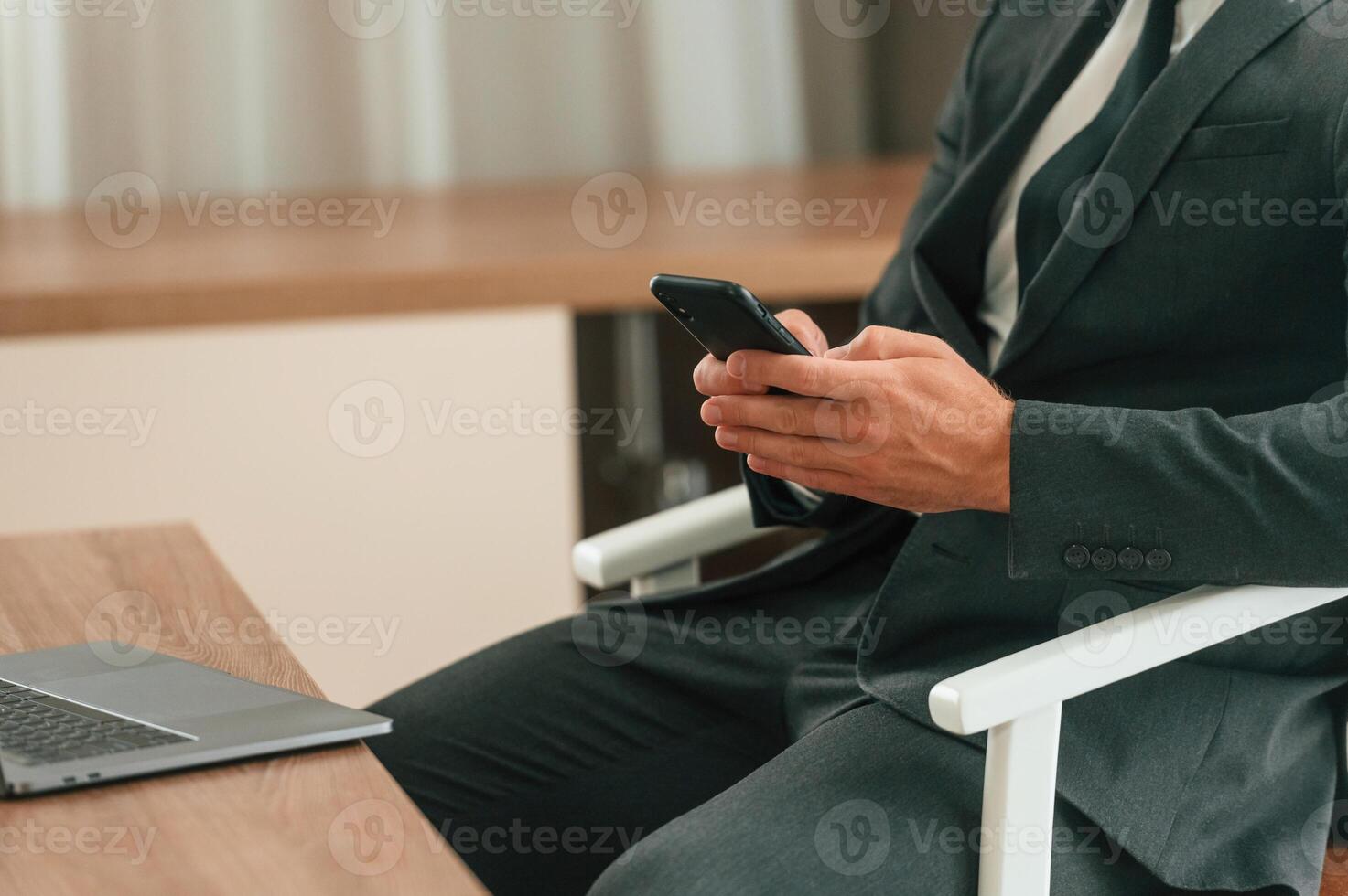 Close up view of businessman that, is sitting and using smartphone photo