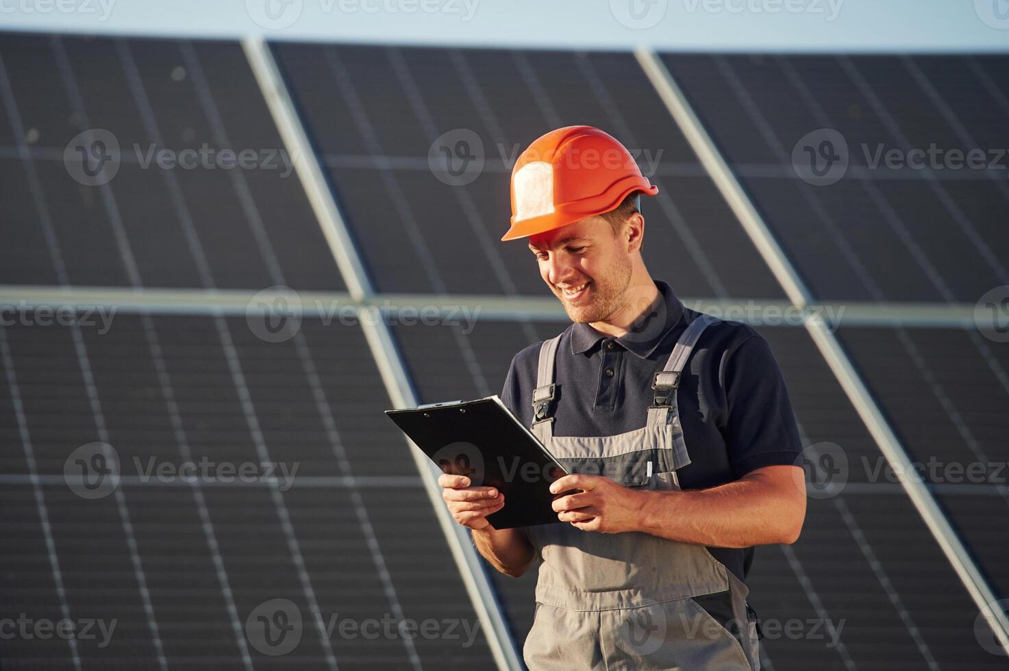 Tablet in hands. Man is doing operating and maintenance in solar power plant photo