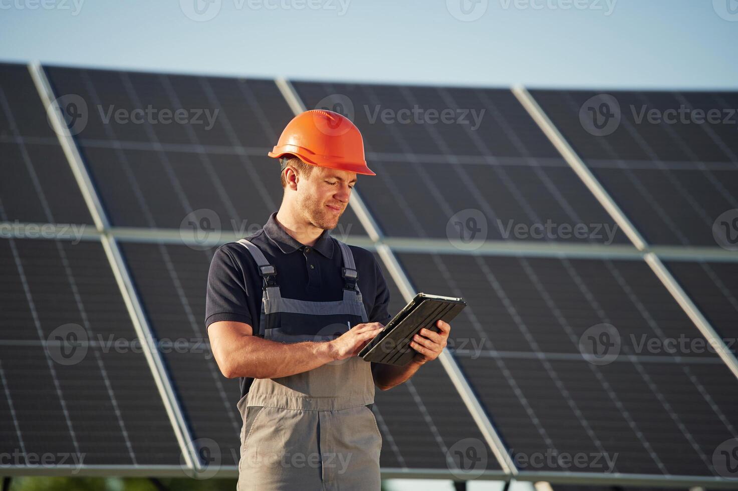 Tablet ,in, hands. Man is doing operating and maintenance in solar power plant photo