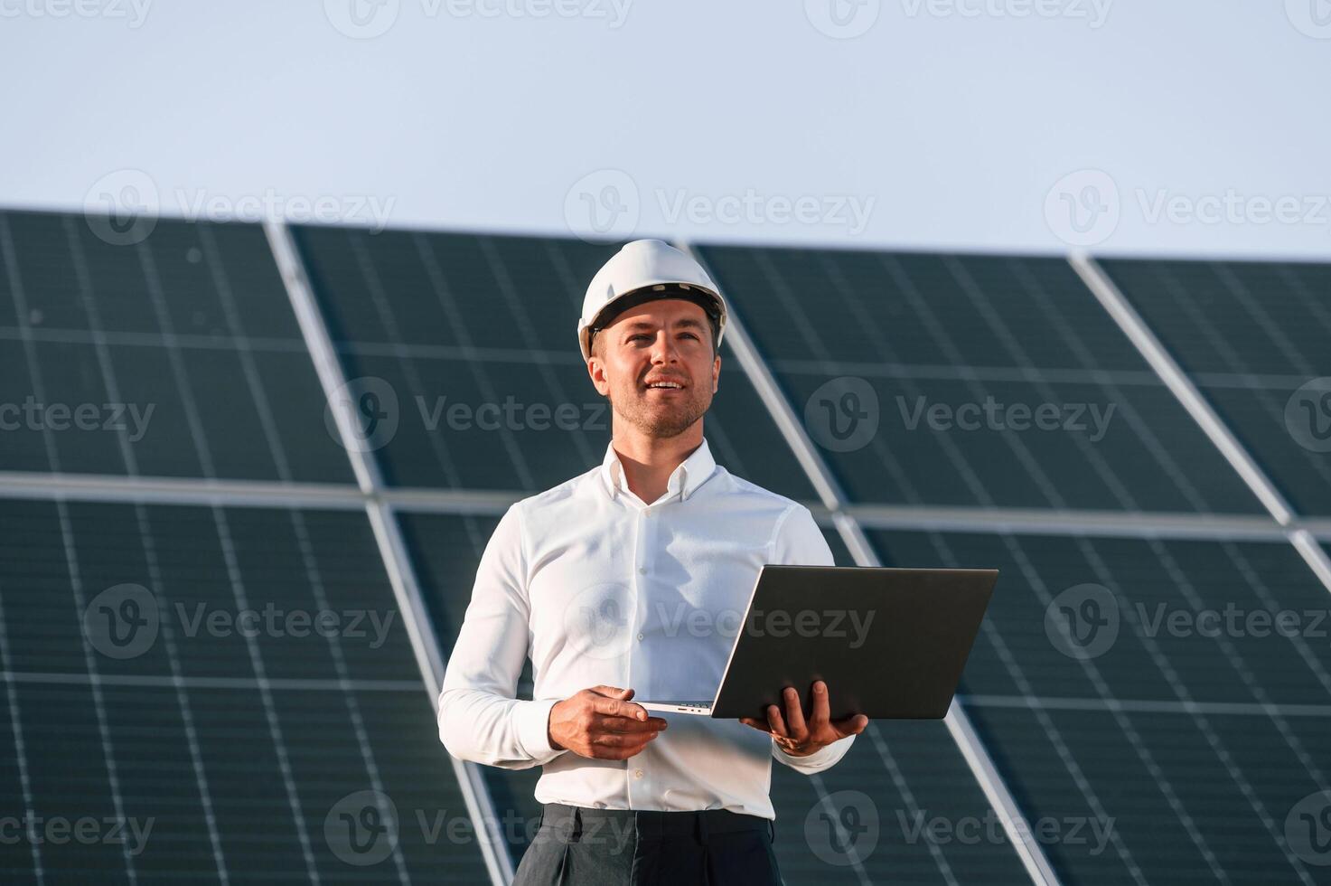 Modern laptop is in hands. Man is ,doing operating and maintenance in solar power plant photo