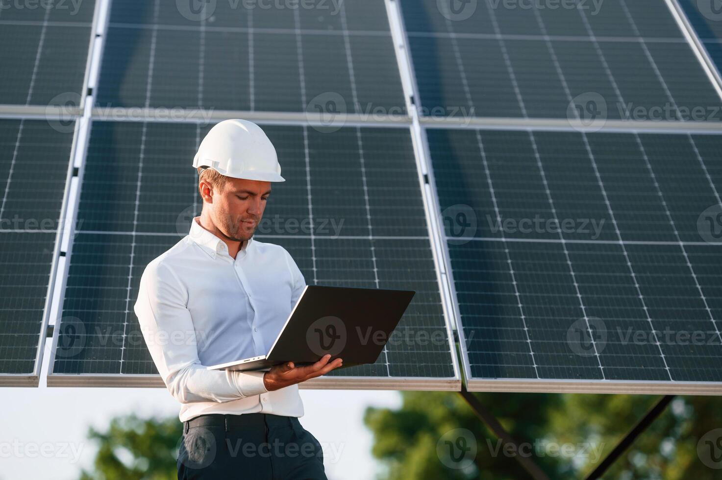 Front, view, holding, laptop. Man is doing operating and maintenance in solar power plant photo