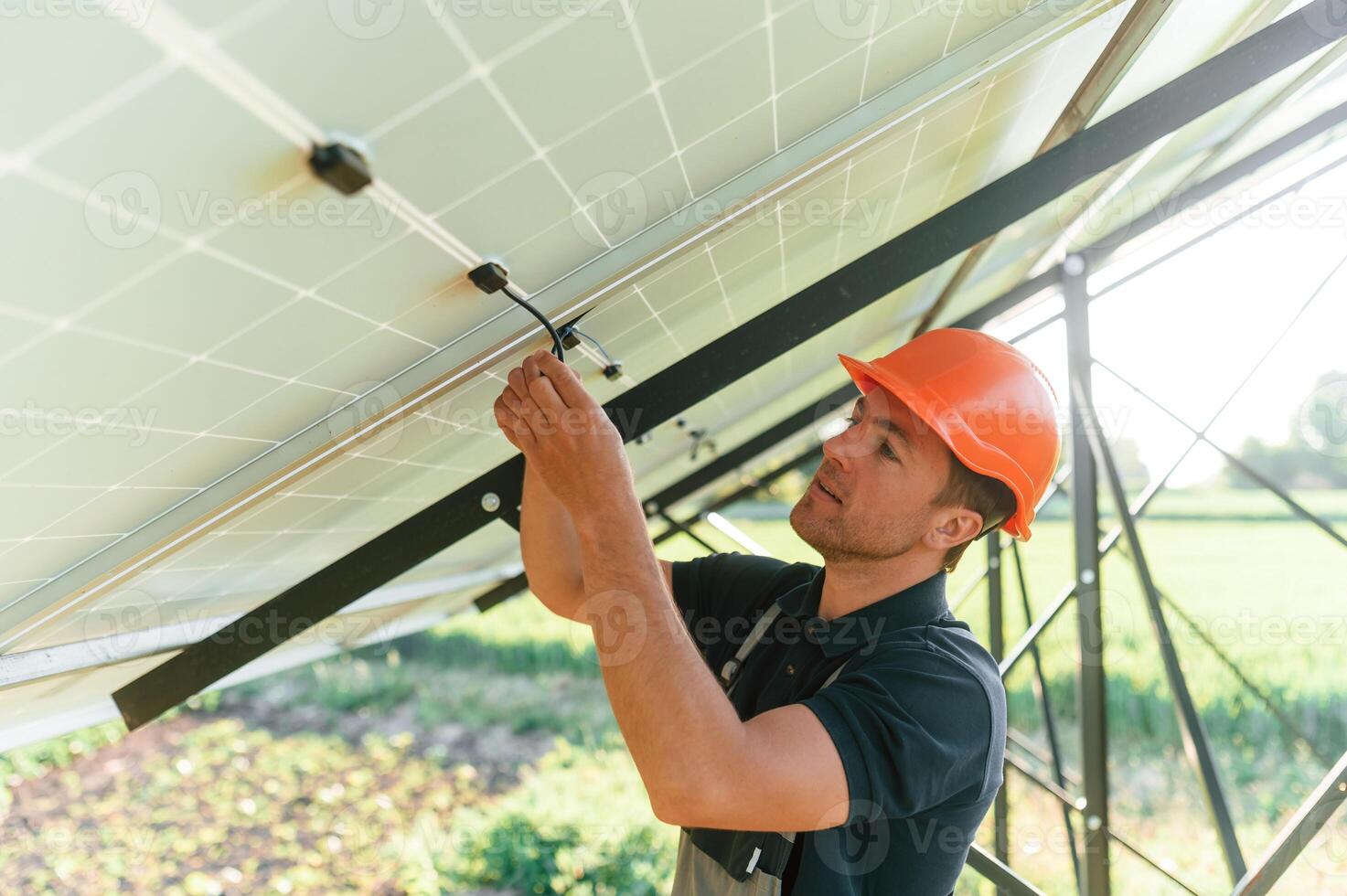 Fixes, the wires. Man is doing operating and maintenance in solar power plant photo