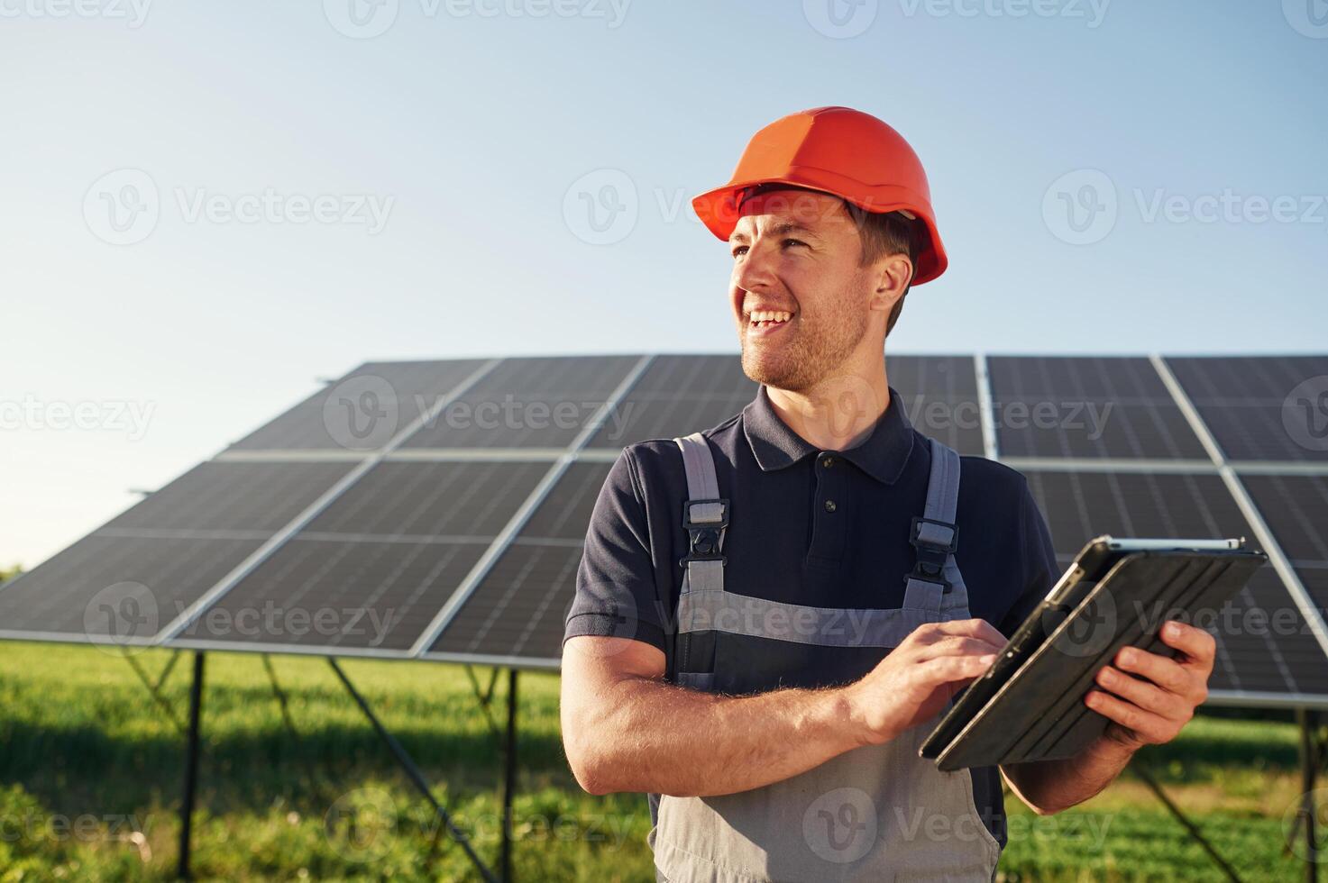 Summer, time,, standing and holding digital tablet. Man is doing operating and maintenance in solar power plant photo