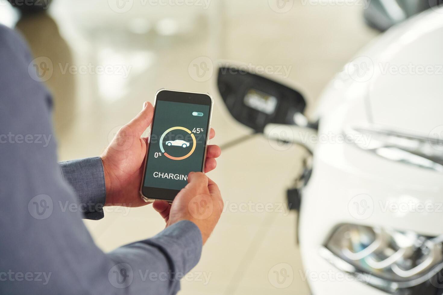 Charging ,process, on ,the smartphone app. Close up view of man that is with electrical car photo