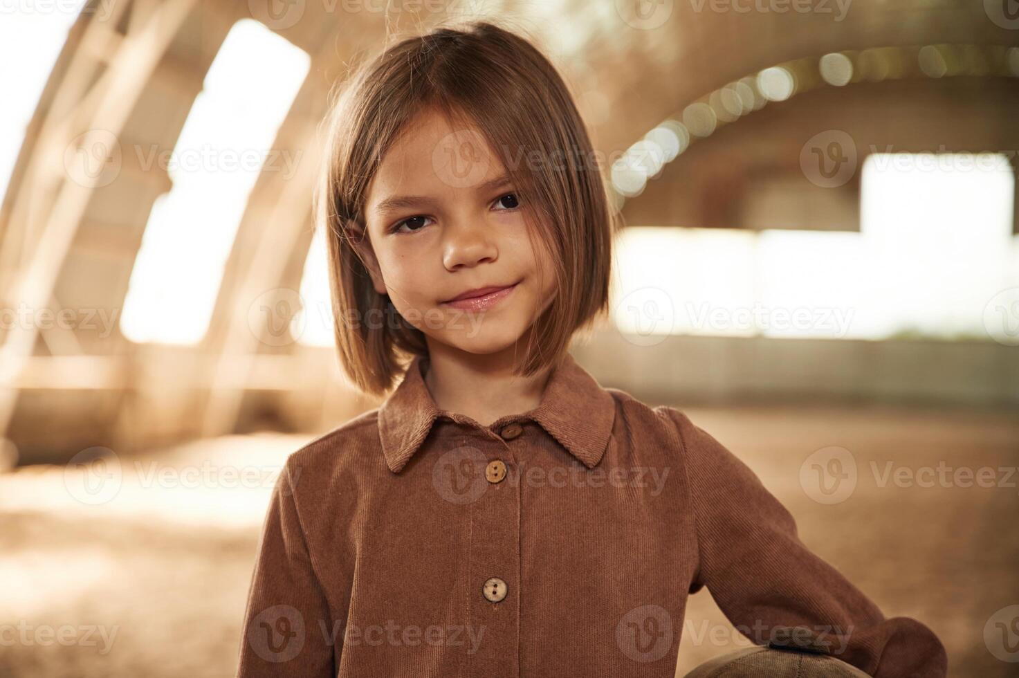 Little girl ,in ,jockey clothes is standing indoors photo