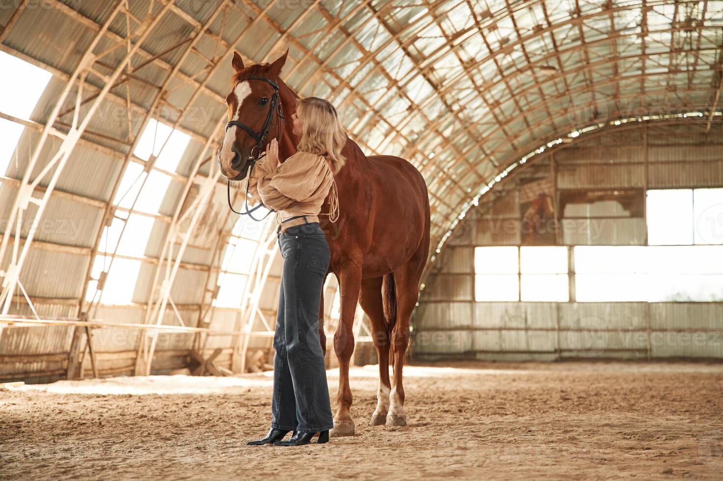 Full height photo. Beautiful ,young woman, is with horse indoors photo