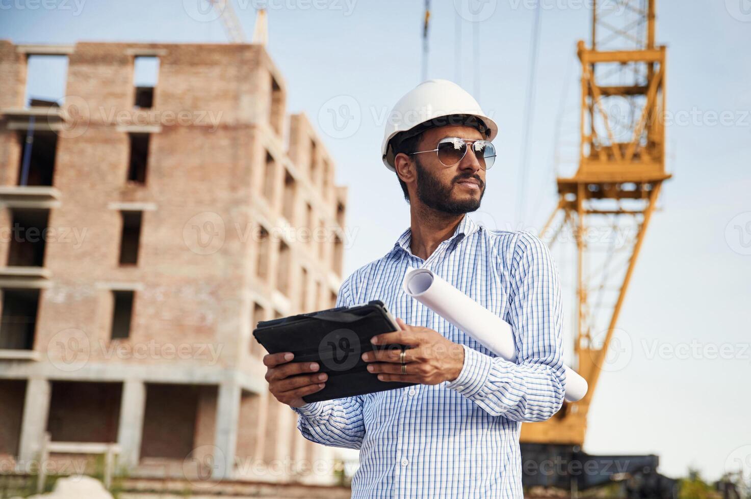 Manager, in sunglasses.. Handsome Indian man is on the construction site photo