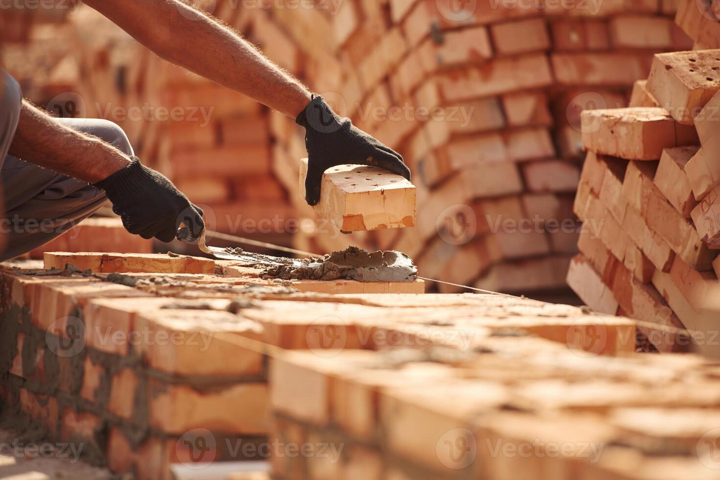Placing the bricks. Close up ,view of man that is working on the construction site photo