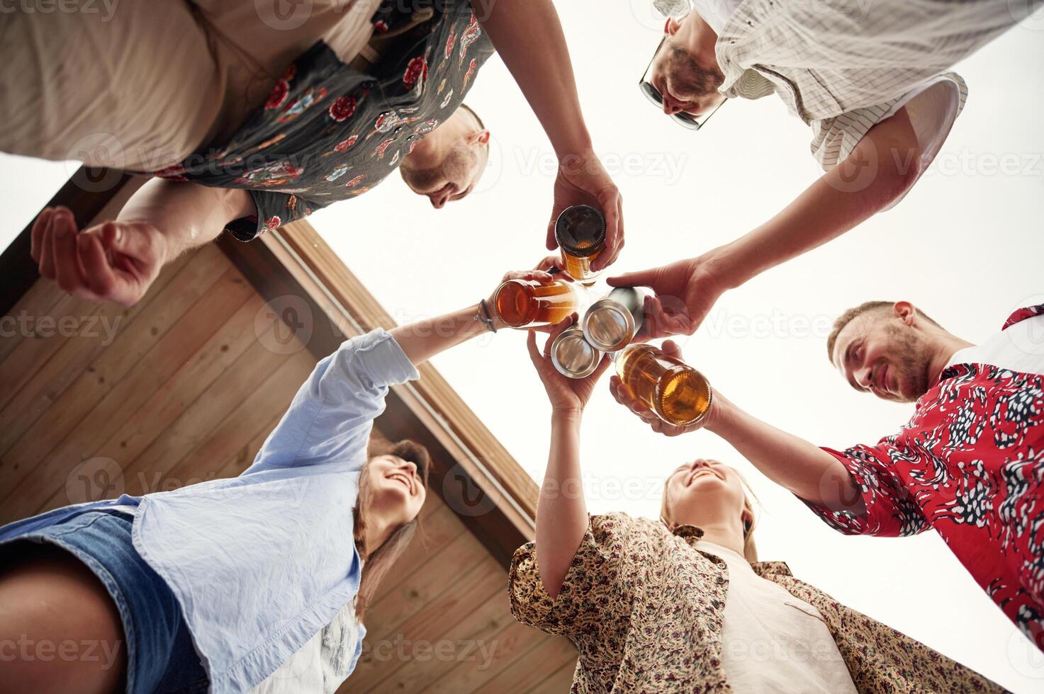 View from below. Group ,of people are with beer in hands having good time photo