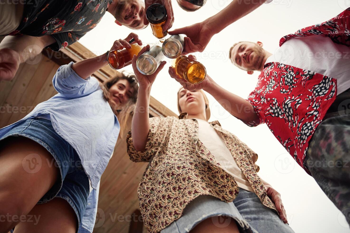 View from below.. Group of people are with beer in hands having good time photo