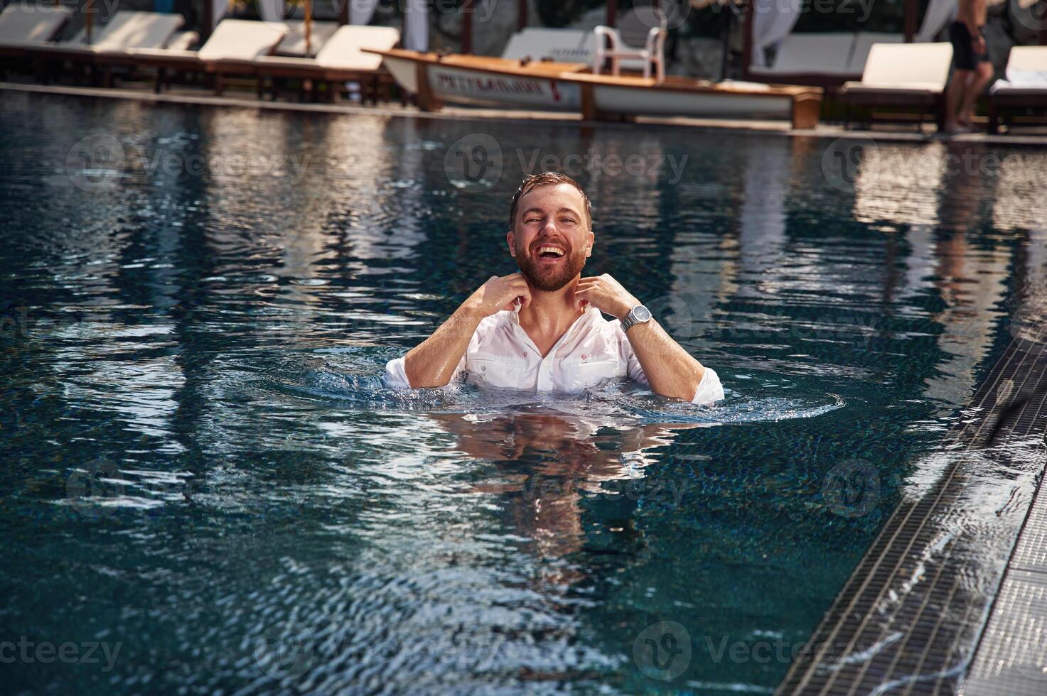 Handsome man in formal ,clothes is in the pool photo