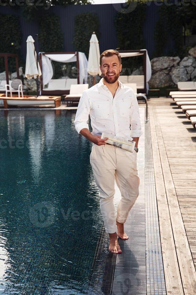 Business look, standing., Handsome, man in formal clothes is in the pool photo