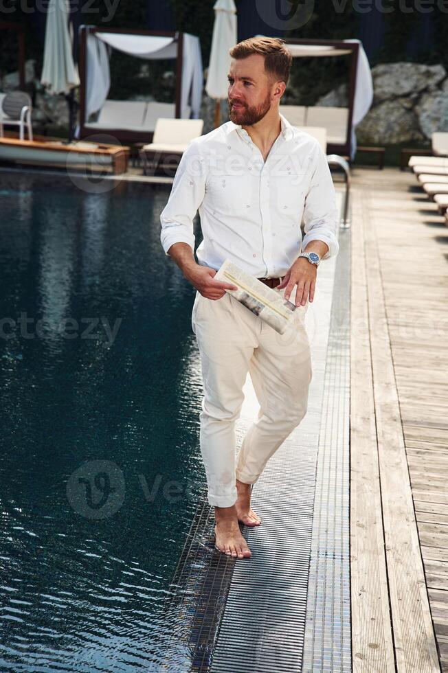 Business look,, standing. Handsome man in formal clothes is in the pool photo