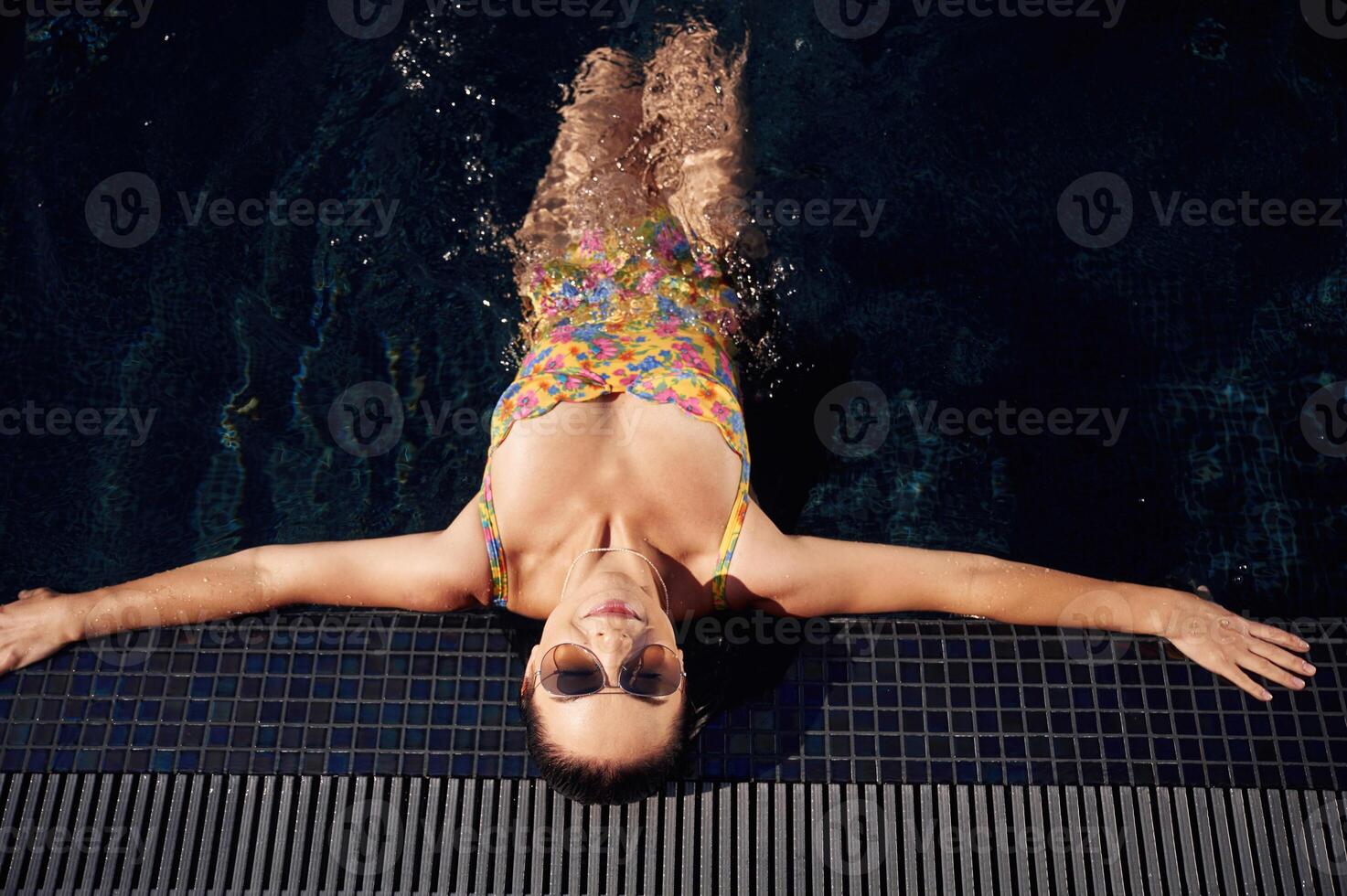 Top view. Beautiful woman ,that is in swimsuit is in the pool photo