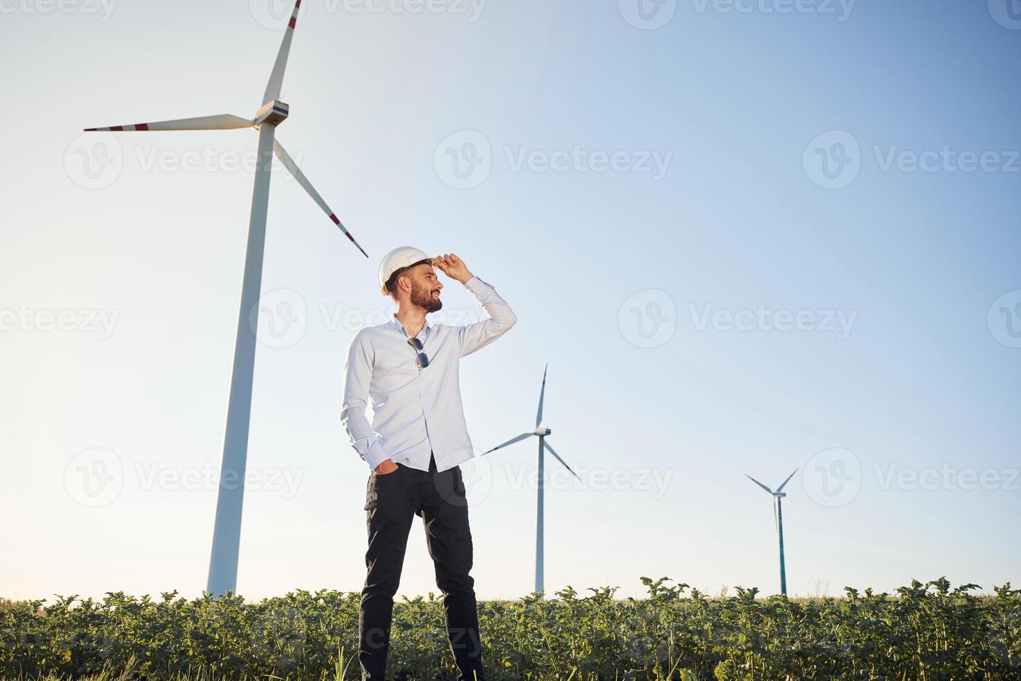 Front view.. Service, engineer is on the field with windmills photo