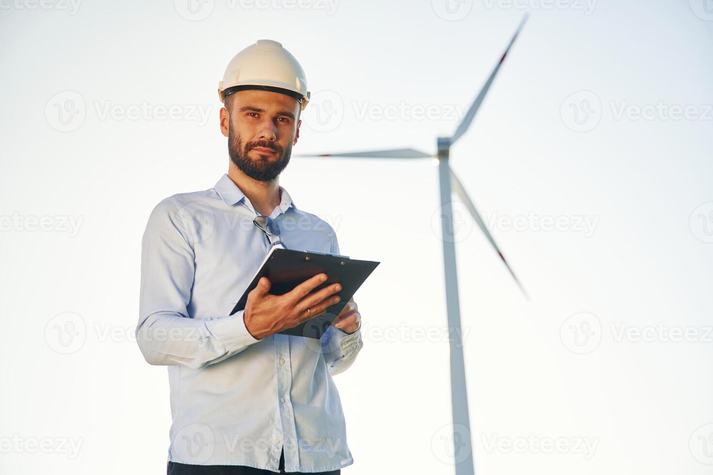 Front view. Service engineer, is on the field with windmills photo
