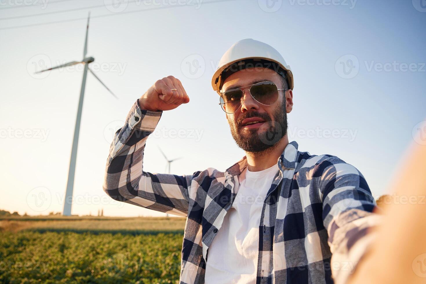 Making selfie.. Service engineer is on the field with windmills photo
