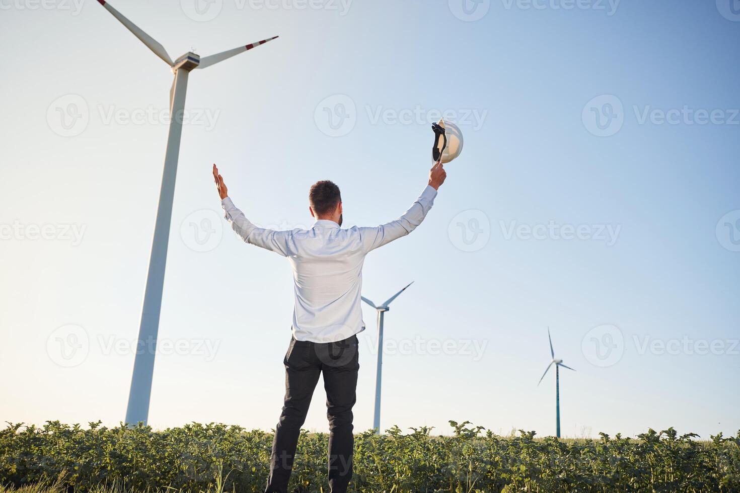 Rear, view. Service engineer is on, the field with windmills photo
