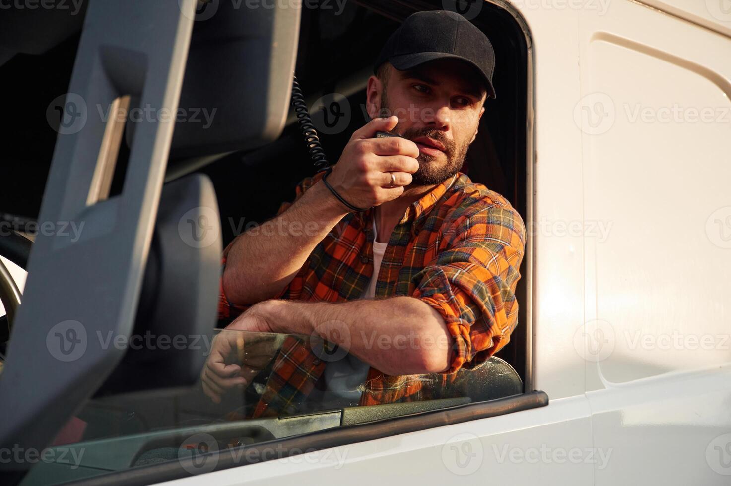 Radio, communication. Young truck ,driver in casual clothes photo