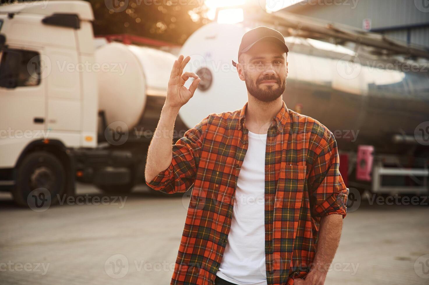 Showing that everything is fine, gesture. Young truck driver in casual clothes photo