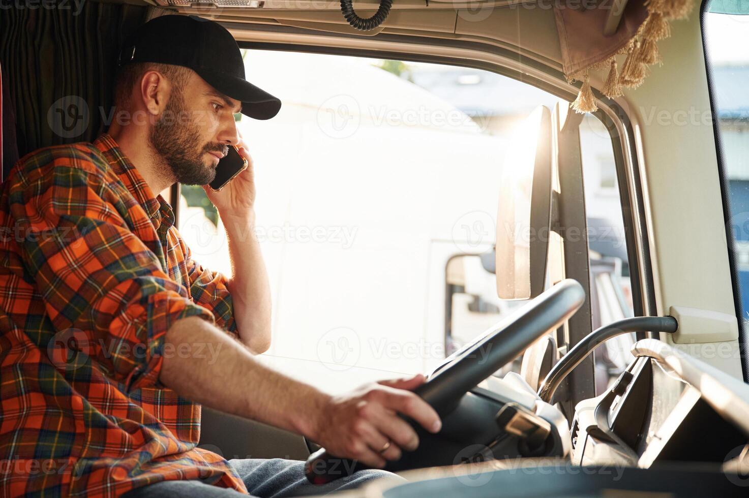 Talking by phone. Young truck driver in casual clothes photo