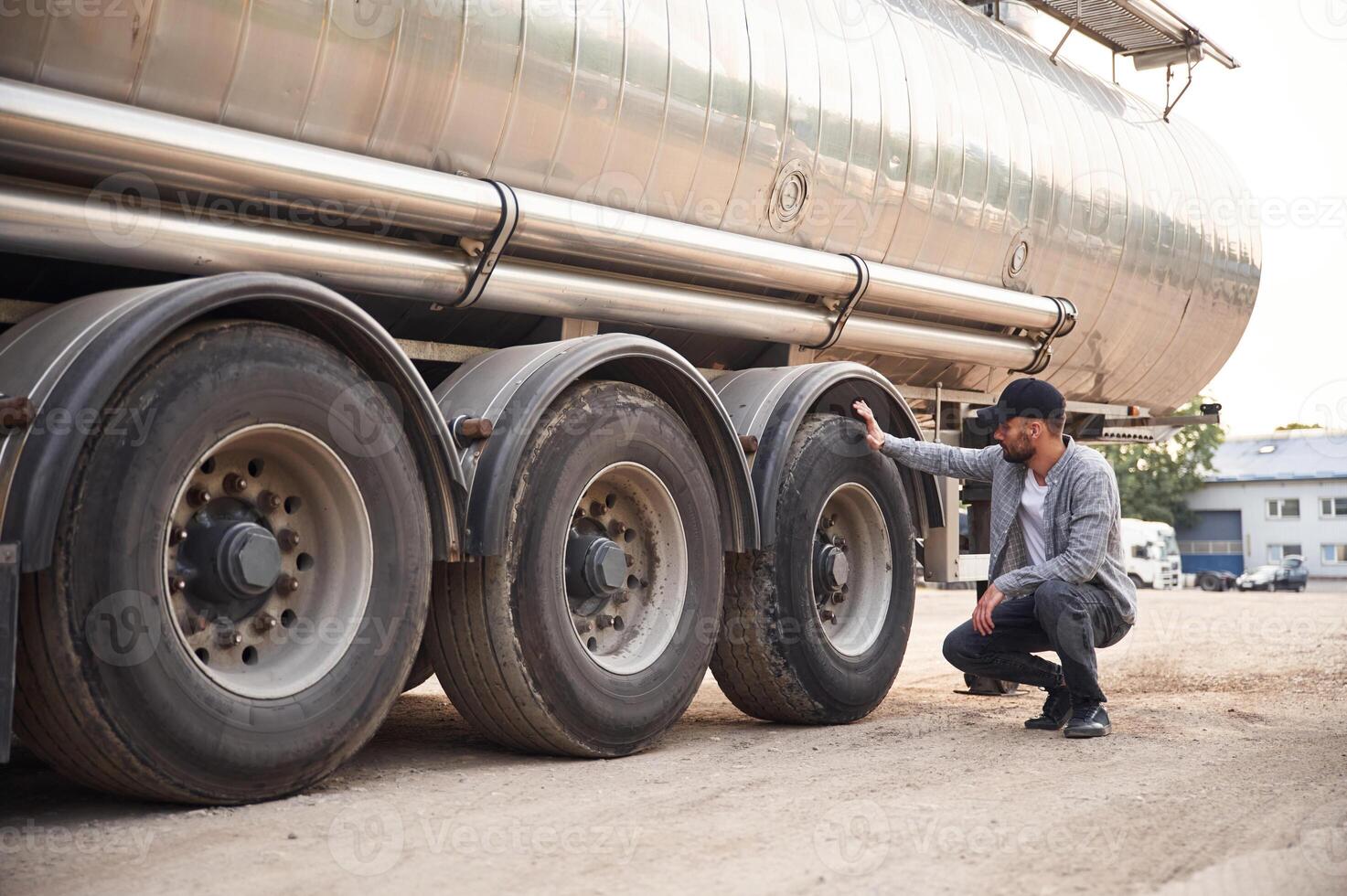 Checking the ,wheels. Young truck driver in casual clothes photo