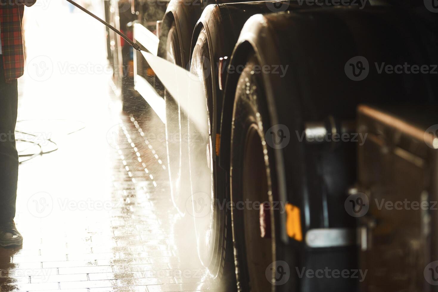 Man is washing the big vehicle indoors., Close up view photo