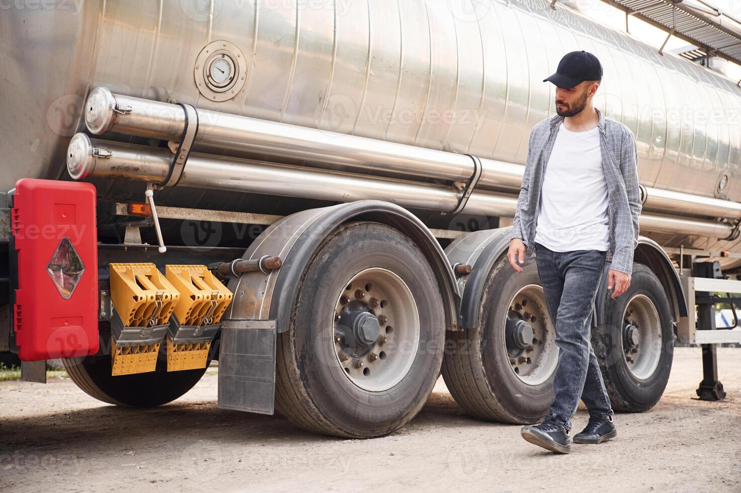 Checking the, vehicle condition.. Young, truck driver in casual clothes photo