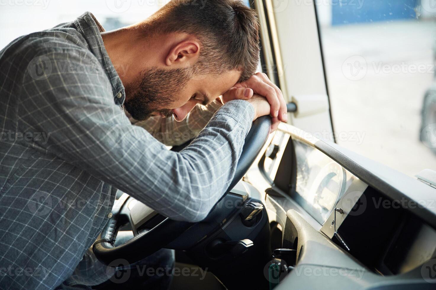 Sitting inside,, tired.. Young truck driver in casual clothes photo