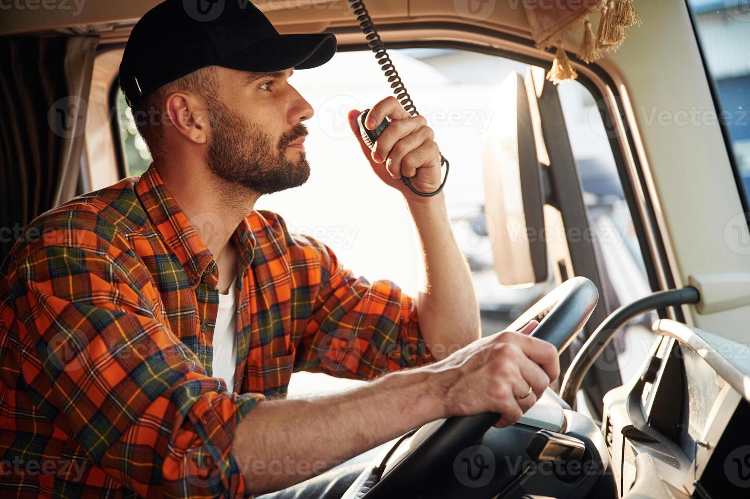 Talking by using, radio. Young truck driver in casual clothes photo