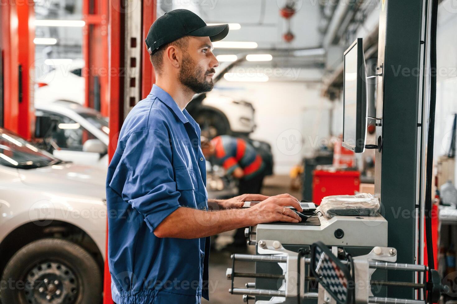 Standing ,by, computer terminal. Auto mechanic working in garage. Repair service photo