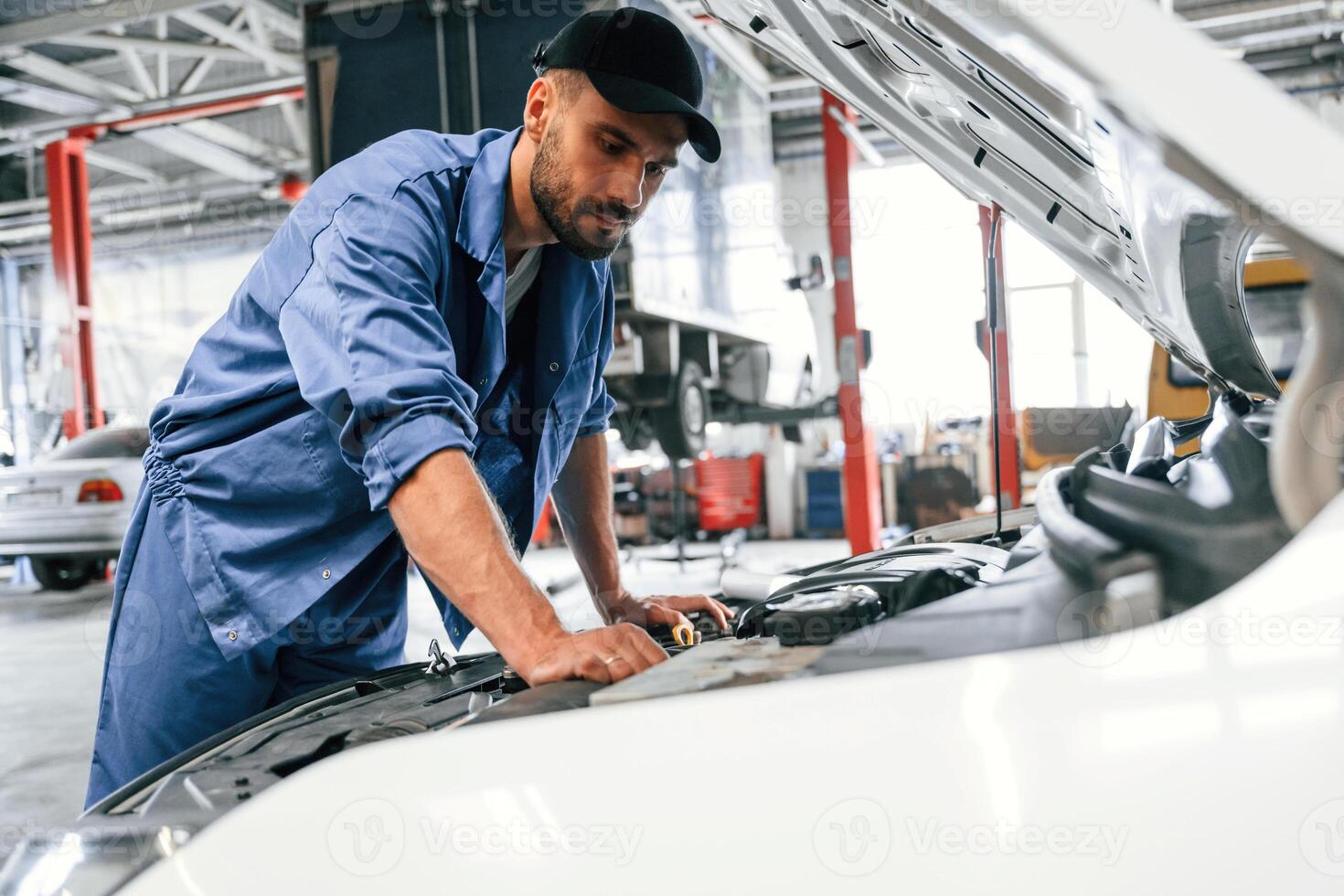 Troubleshooting process. Auto mechanic working in garage. Repair service photo