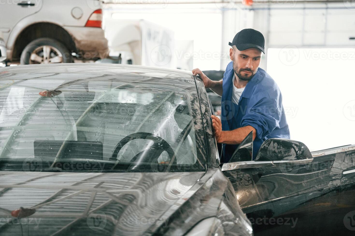 Moving the dirty ,car that need washing. Auto mechanic working in garage. Repair service photo