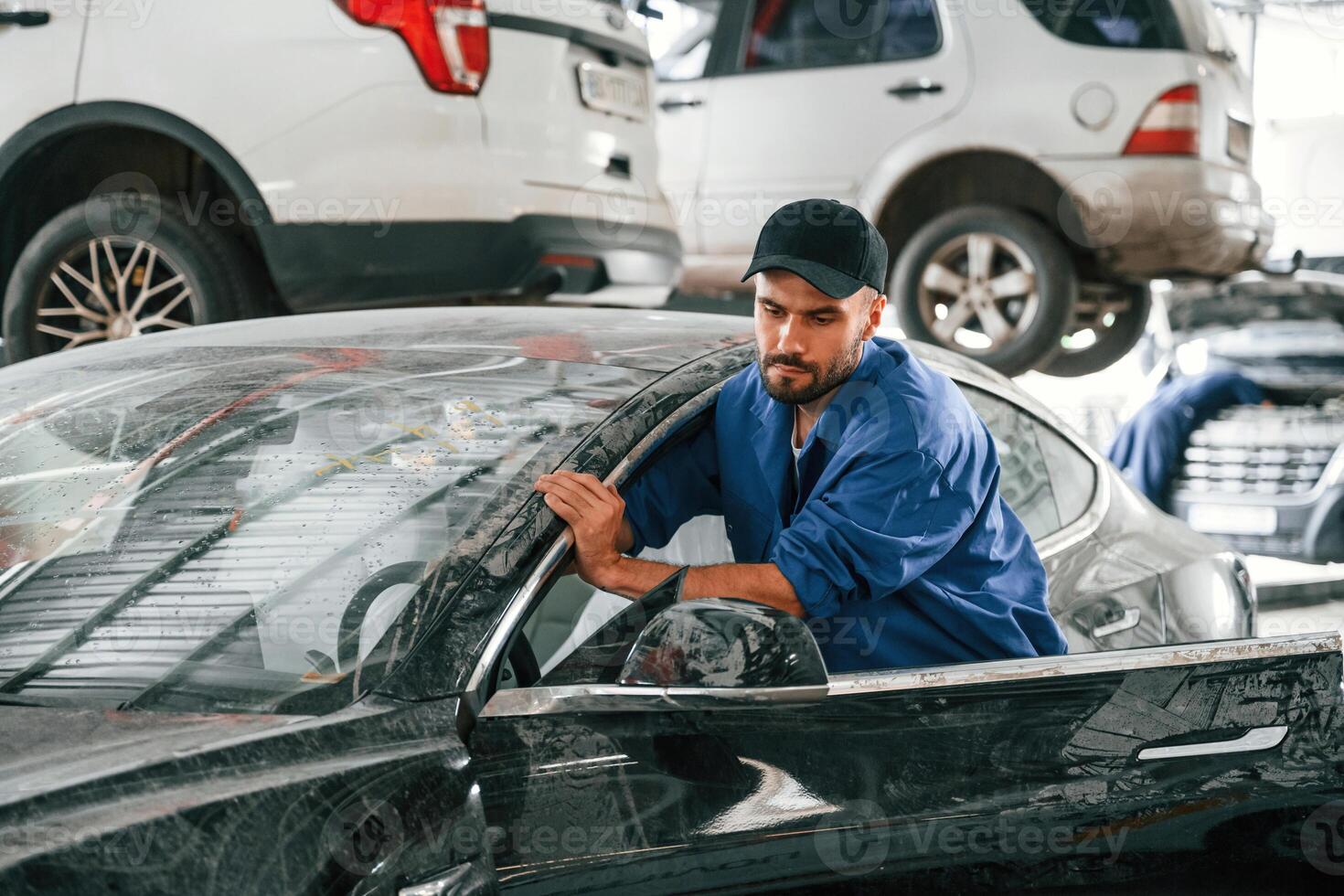 Dirty car is moved by, auto mechanic that is in garage. Repair service photo