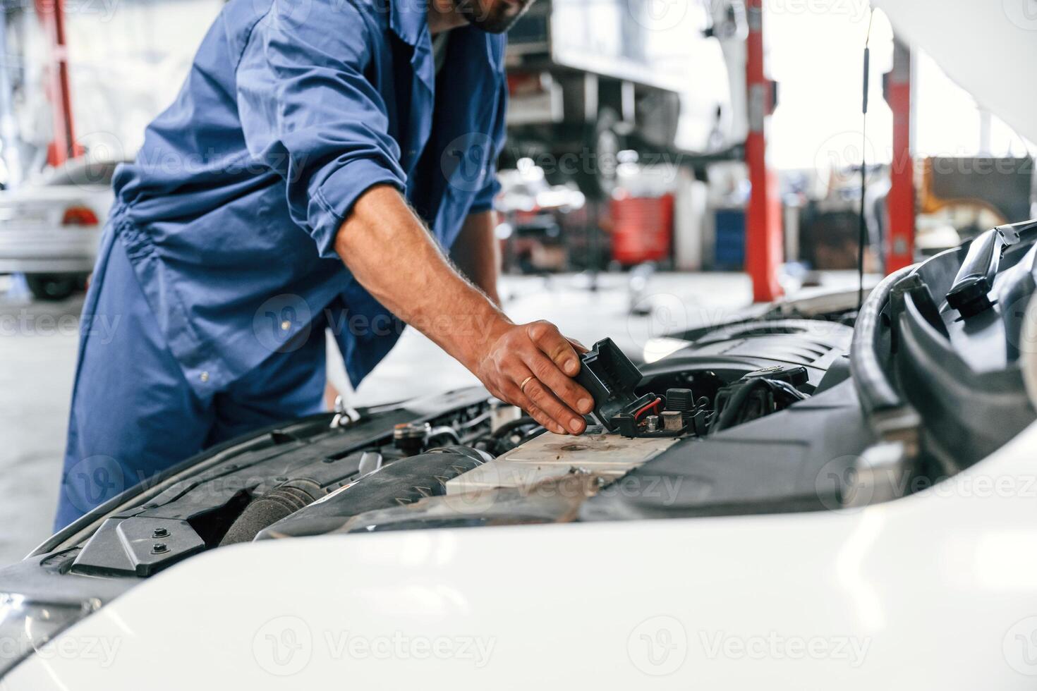 Troubleshooting process. Auto, mechanic working in garage. Repair service photo