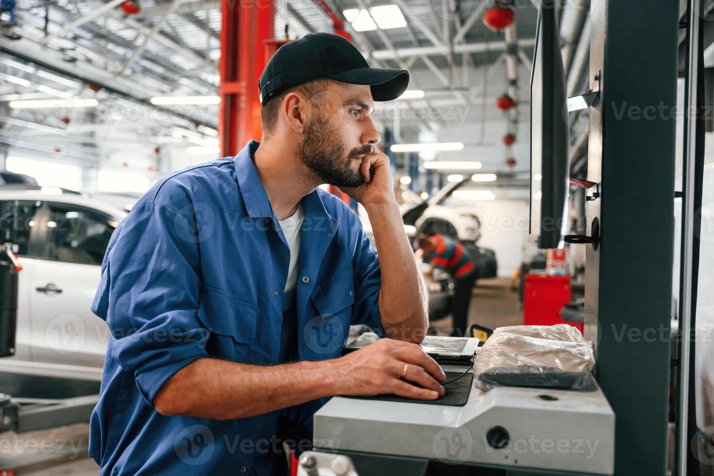 Side view, using, computer. Auto mechanic working in garage. Repair service photo
