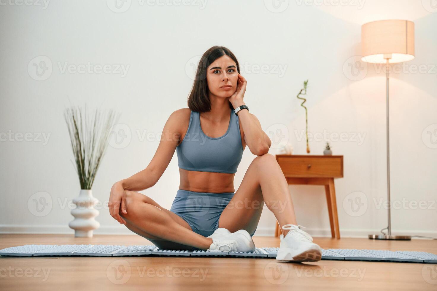 On ,yoga mat.,. Pretty woman in sportive clothes have fitness day indoors photo