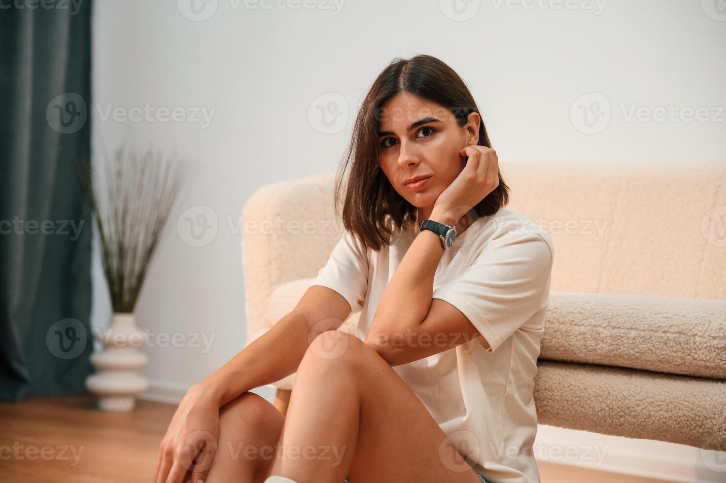 On the, floor. Beautiful, woman in casual clothes is at home in domestic room photo